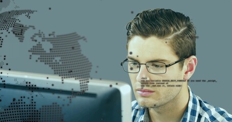 Developer wearing glasses reviewing code on monitor at desk, with world map overlay, code overlay