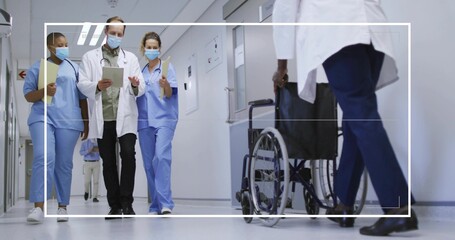 Medical staff in uniforms walking in hospital corridor with tablet, clipboards, masks, wheelchair © vectorfusionart