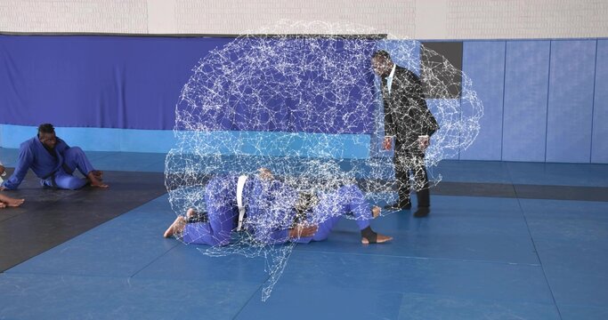 Grappling fighters in blue uniforms controlling opponent on back in gymnasium, with brain overlay