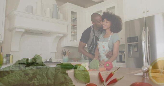 Couple cooking in kitchen, man planting kiss and sparking floating produce overlay