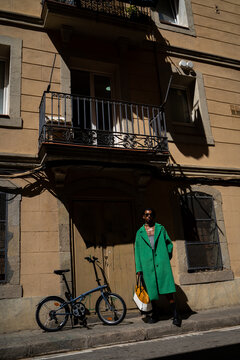 Fancy man with bike and bag outside ancient building
