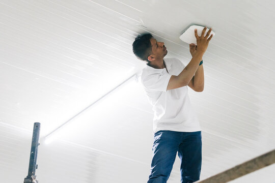 Man fixing router on ceiling in glowing lights