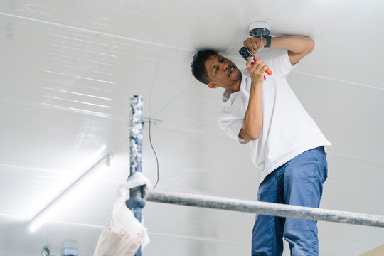 Man installing security camera on ceiling
