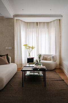 A modern living room with a white sofa and armchair