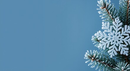 A frosted evergreen branch with a decorative snowflake against a blue background. Minimalist winter and Christmas holiday banner with copy space