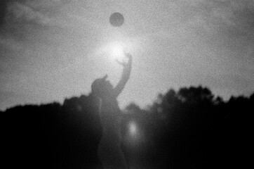 Woman playing volleyball against the light