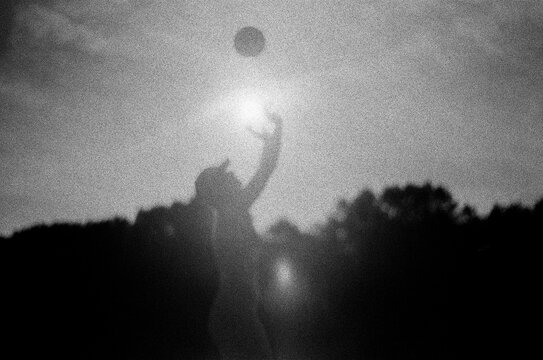 Woman playing volleyball against the light