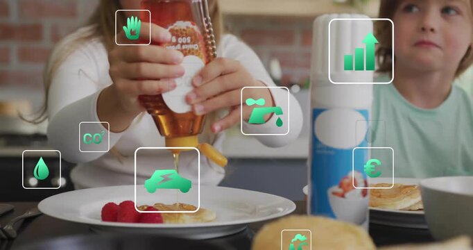 Siblings pouring honey onto pancakes to sweeten breakfast sparking green icons swirling around them