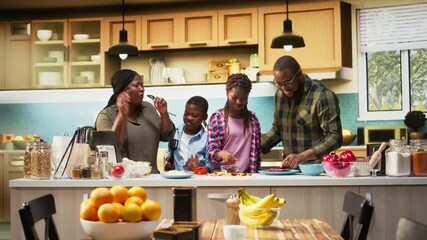 African american young family singing and dancing around in the kitchen, acting silly and laughing together for fun weekend activity. Goofy kids and parents using utensils for karaoke. Camera A. - Powered by Adobe