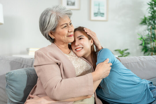 Asian young daughter hug her older mother in living room at home.