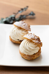 Cream puffs with whipped cream filling on a white plate