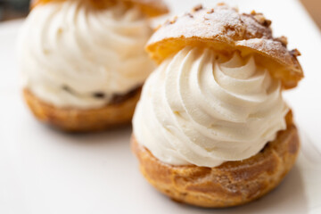Cream puffs with whipped cream filling on a white plate