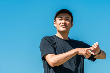 Fototapeta premium A middle-aged man in sportswear using a smartwatch, pedometer, and pedometer to manage his health and wellness 