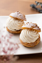 Cream puffs with whipped cream filling on a white plate