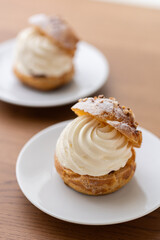 Cream puffs with whipped cream filling on a white plate