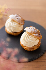 Cream puffs with whipped cream filling on a white plate