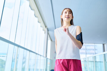 屋内でランニングする若い女性　スポーツジム