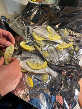 Preparing whole fish with lemon slices for baking