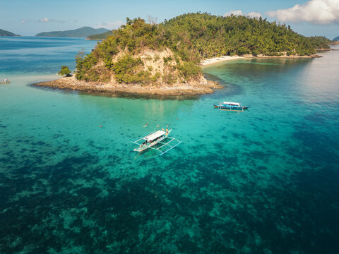 Turquoise ocean with boats and tropical island