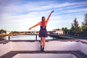 woman on bridge overlooking rio gil&atilde;o at sunset, tavira, algarve
