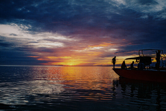 Unrecognisable group of people aboard a yacht at sunset 