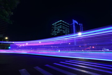 The highway car rainbow light trails of modern city buildings