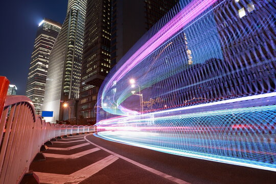 The highway car rainbow light trails of modern city buildings