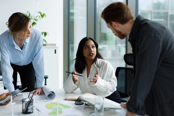 Male and female architects listening woman colleague telling to them