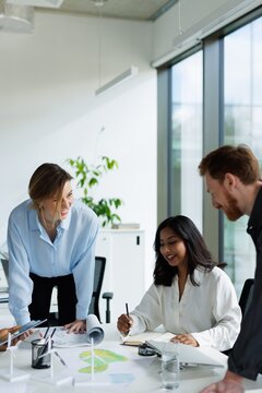 Smiling multiracial architects discussing about windmill farm project