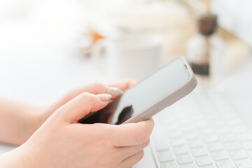 A woman with nails touching the screen of a smartphone
