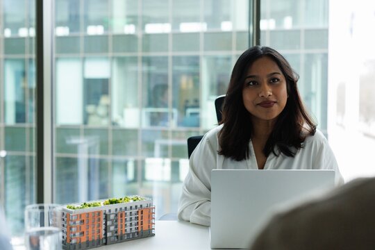 Smiling real estate agent looking at cropped unknown person client