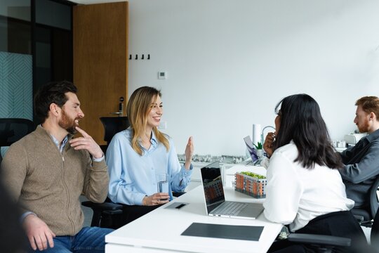 Young female real estate agent talking with pleased couple clients