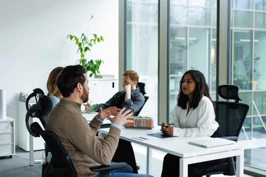 Real estate agent listening client while he visiting agency with wife