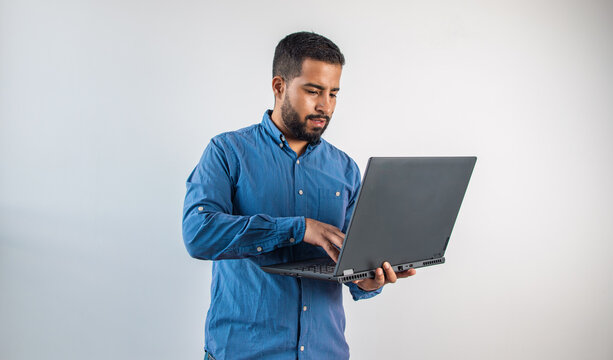 Young man working on laptop standing up - Powered by Adobe
