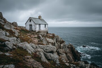 Isolated white dwelling sits perched atop a rugged coastal cliff overlooking a dark sea