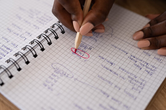 Woman highlighting money amount in notebook