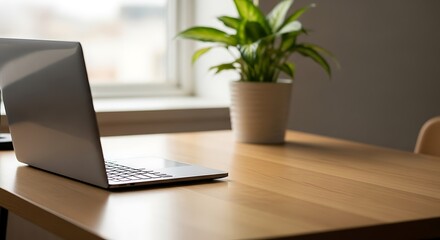 Minimalist home office setup with laptop on wooden desk.