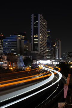 Bangkok city at night with passing train light trails