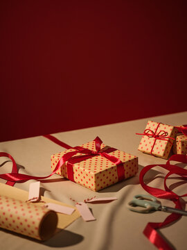 Christmas gift wrapping preparation with red ribbon and polka dots