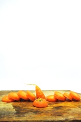The fresh orange carrots or daucus carota on an old wooden chopping board