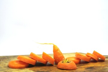 The fresh orange carrots or daucus carota on an old wooden chopping board