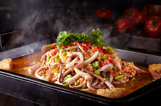 Spicy braised squid tentacles in a wok, close-up