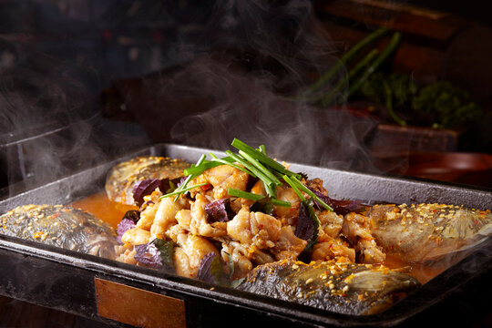 Wok-fried frog meat with perilla and fish head, closeup