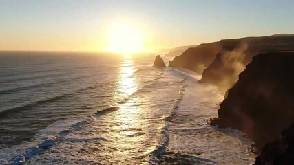 4K drone cinematic sunrise over rugged coastal cliffs with soft mist and glowing waves. Peaceful and inspiring travel footage. - Powered by Adobe