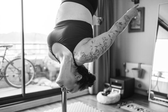 Black and White Photo of Woman in Inverted Pole Pose