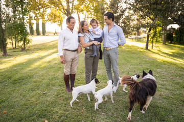 Happy Spanish family with dogs in garden of big house