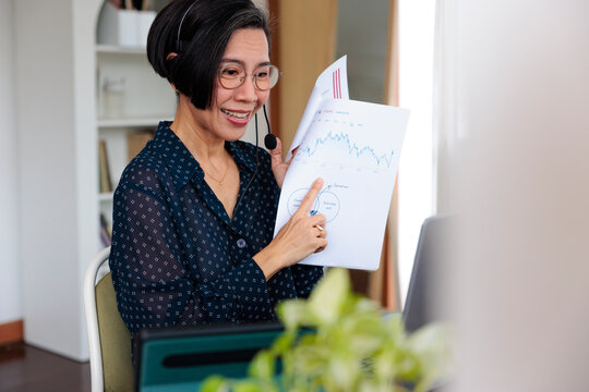 Woman presenting financial data via video call.