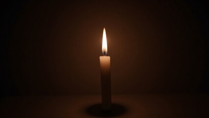 Candle flame glowing in the darkness, creating a warm ambiance indoors
