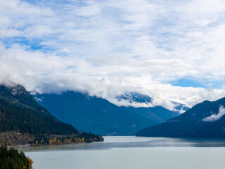Serene Mountain Lake With Snowy Peaks and Misty Clouds Across BC, Canada