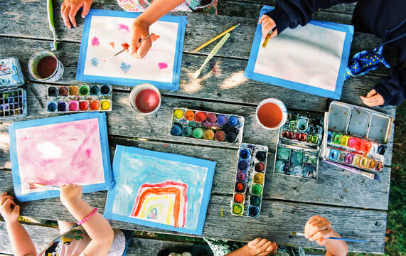 Children make art on a picnic table